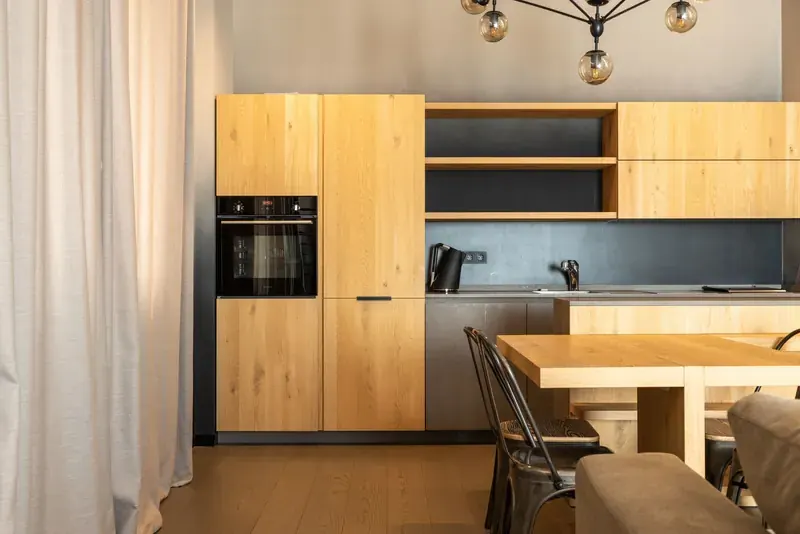 Renovated kitchen with oak cabinets, a built-in oven and a wooden table